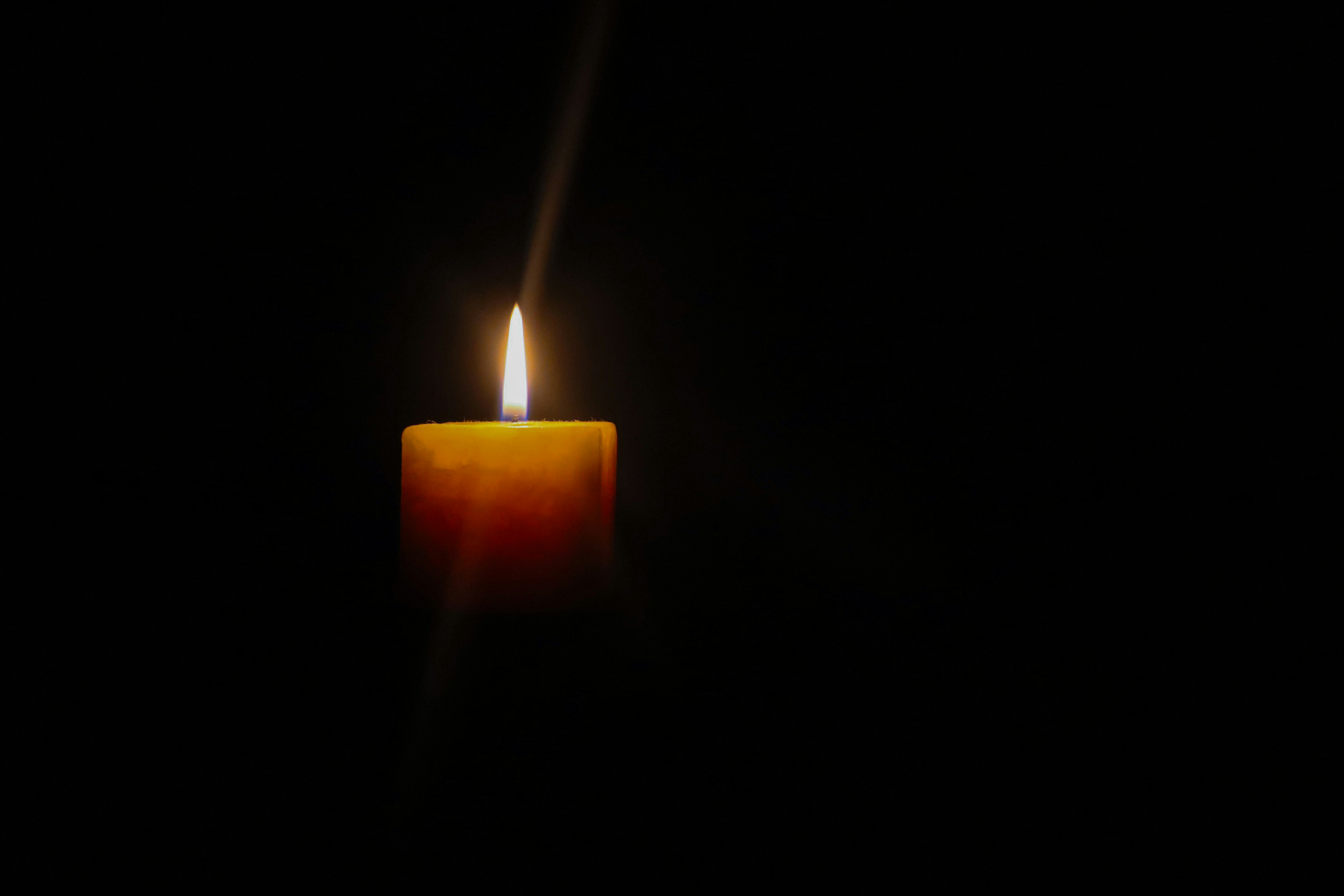 A single candle glowing in the dark