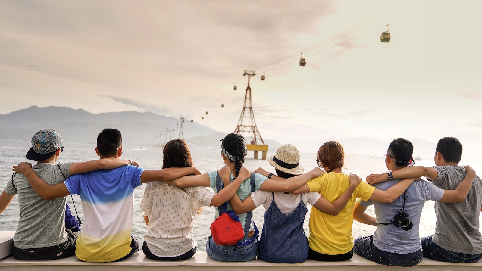 A group of family and friends sitting arm in arm looking out at a view